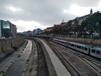 Railroad tracks in city against sky
