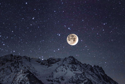 Low angle view of snowcapped mountains against sky
