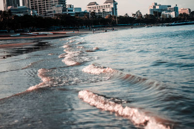 Water flowing in city by sea against sky