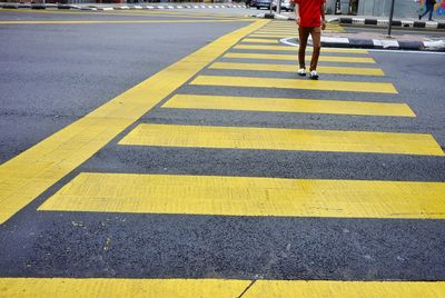 Low section of woman walking on zebra crossing