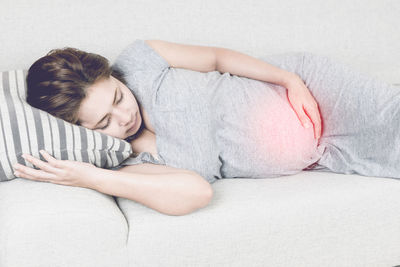 Digital composite of pregnant woman touching abdomen while lying on bed