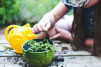 Girl planting plant in yard