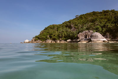 Scenic view of rocks in sea against clear sky