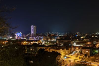 High angle view of illuminated buildings against sky at night