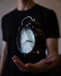 Close-up of hand holding clock