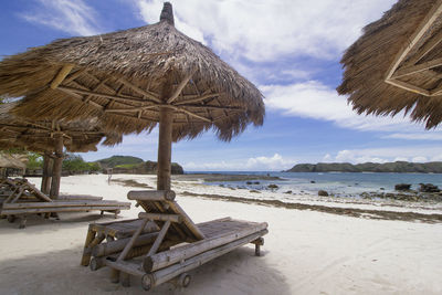 Traditional windmill on beach against sky