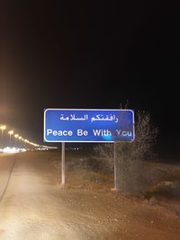 Information sign on road against clear sky at night