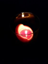 Close-up of lit candle in dark room