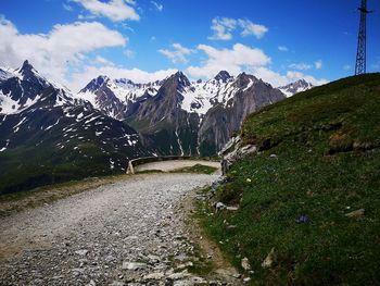 Road amidst snowcapped mountains against sky