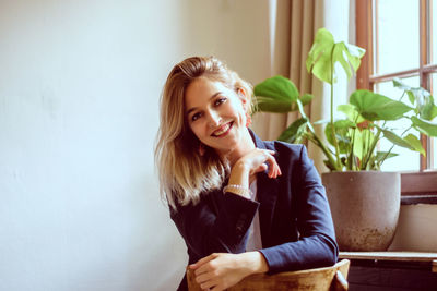 Portrait of smiling woman sitting at home