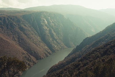 High angle view of valley and mountains against sky