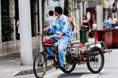 Man riding bicycle on street in city