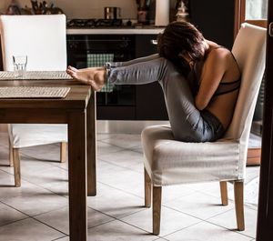 Man using mobile phone while sitting on table at home