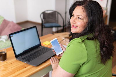 Portrait of woman using laptop on table