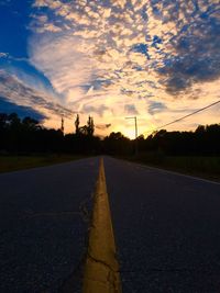 Surface level of road against cloudy sky