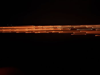 Blurred motion of illuminated lights against black background