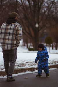 Rear view of boy standing on snow