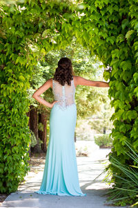 Rear view of young woman wearing gown while standing in park