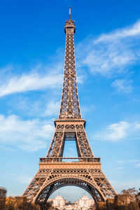 Low angle view of eiffel tower against cloudy sky in paris. 