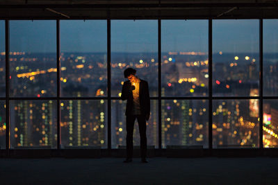 Man with fire standing by window