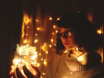 Close-up of illuminated young woman