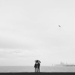 Silhouette couple under umbrella at montrose harbor