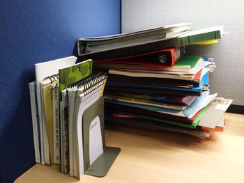 Close-up of books by folders on wooden table