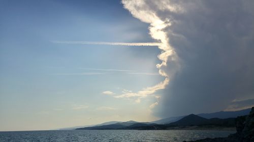 Scenic view of sea and vapor trail in sky