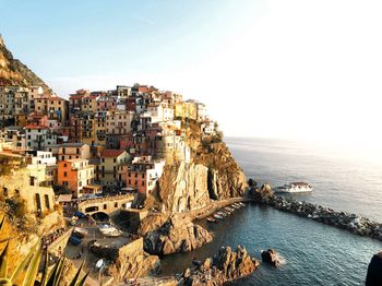 High angle view of buildings by sea against clear sky