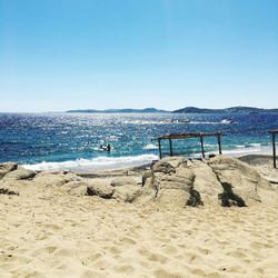 Scenic view of beach against clear blue sky