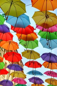 Low angle view of umbrellas hanging against sky