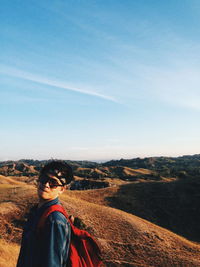 Portrait of man standing on landscape against sky