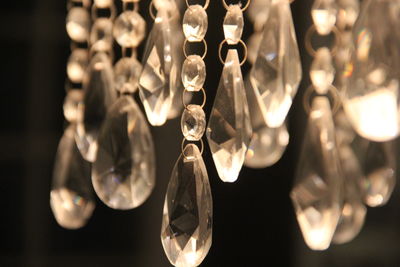 Close-up of illuminated light bulbs hanging from glass