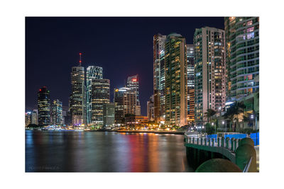 Illuminated buildings against sky at night