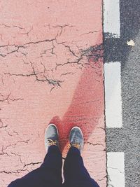 Low section of man standing on cracked street