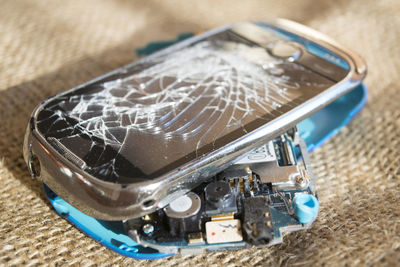 Close-up of broken mobile phone on table