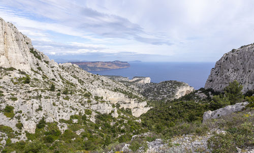 Scenic view of sea and mountains against sky