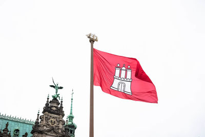 Low angle view of red flags against sky