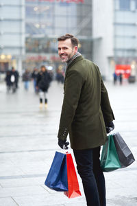 Young man with umbrella in city