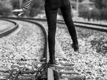 Low section of woman standing on railroad track