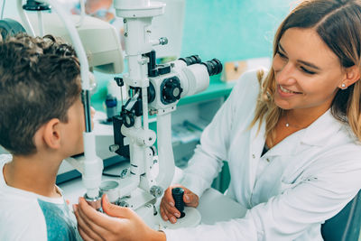 Smiling ophthalmologist doing eye test of boy