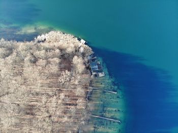 High angle view of sea and buildings against blue sky