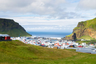 Scenic view of beach by buildings against sky