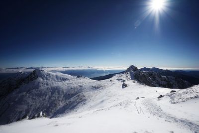 Scenic view of snowcapped mountains against clear blue sky