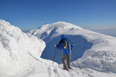 Rear view of man skiing on snow landscape