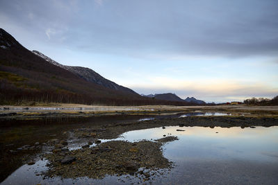 Scenic view of lake by mountain against sky