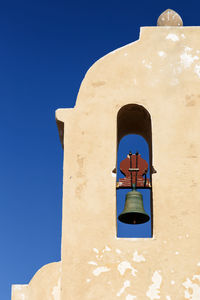 Low angle view of bell tower against blue sky