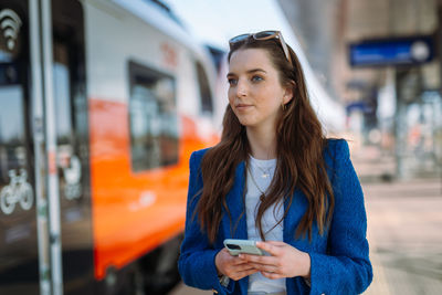 Woman entrepreneur commuting to work. using and holding mobile phone. public transport concept.