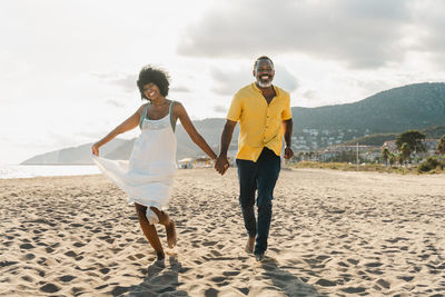 Rear view of couple standing at beach