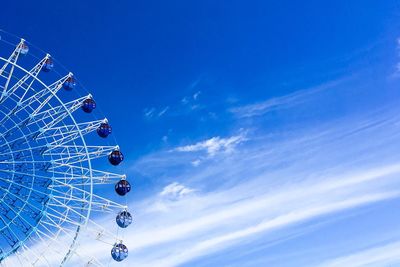 Low angle view of ferris wheel against blue sky